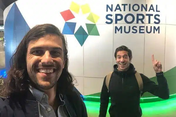 two men pointing to the national sports museum sign