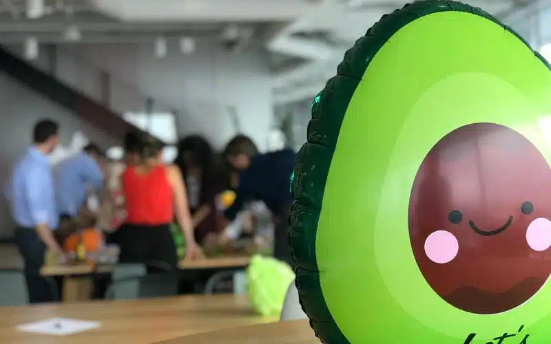 an inflatable avocado, with people gathered in the background