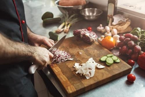 A photo of a person chopping vegetables